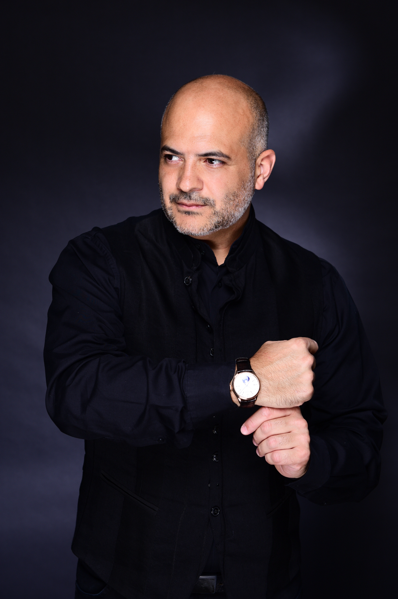 Gaston Rivero adjusting his watch in a black outfit