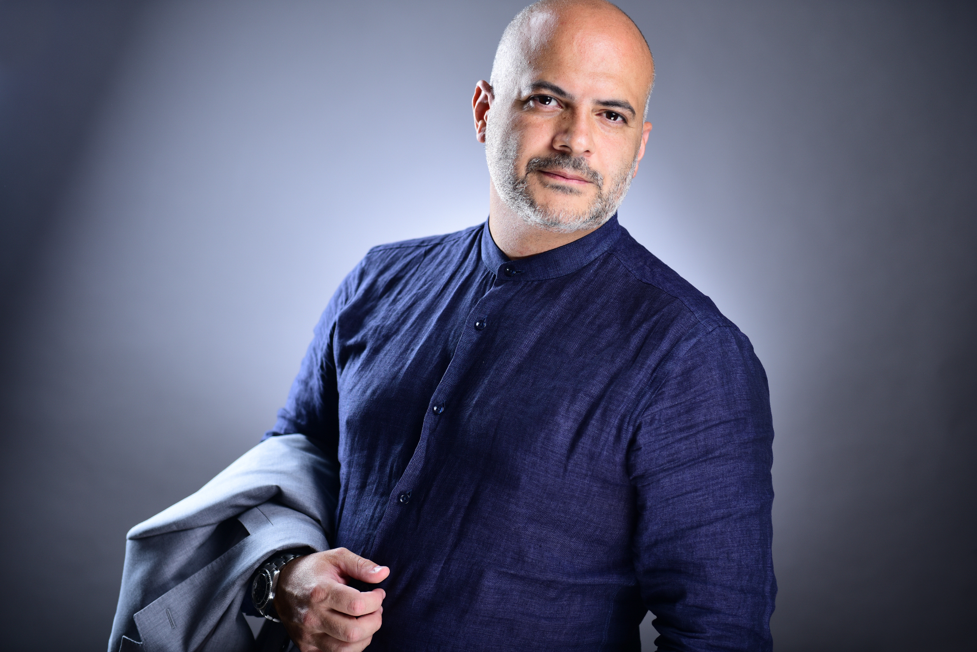 Gaston Rivero in navy shirt holding a jacket